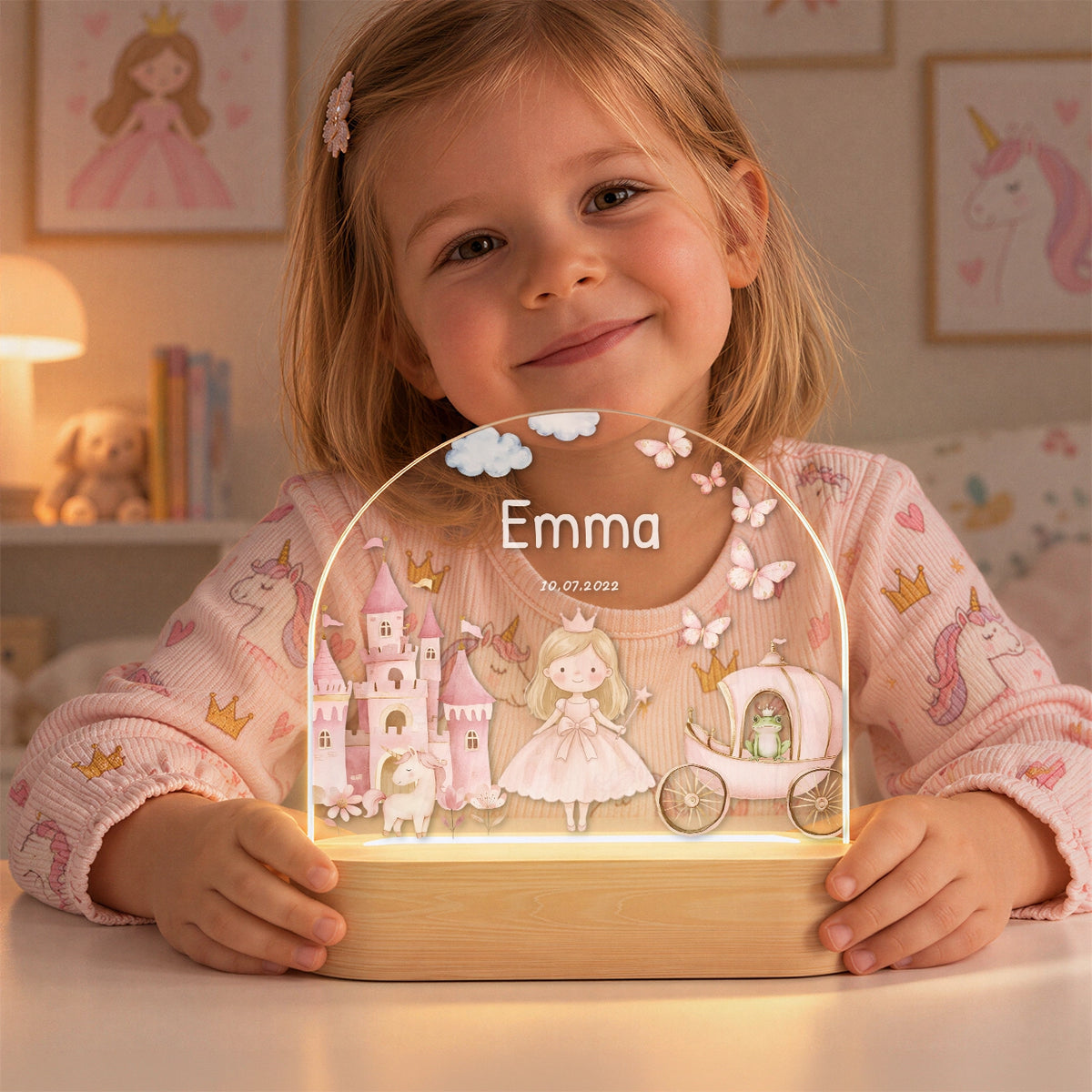 Lächelndes Mädchen hält das leuchtende Prinzessin-Nachtlicht mit Namen