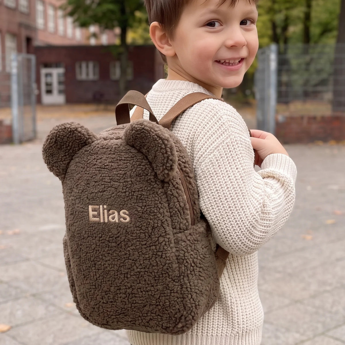 Junge trägt den Teddy Rucksack in Taupe mit dem Namen „Elias“