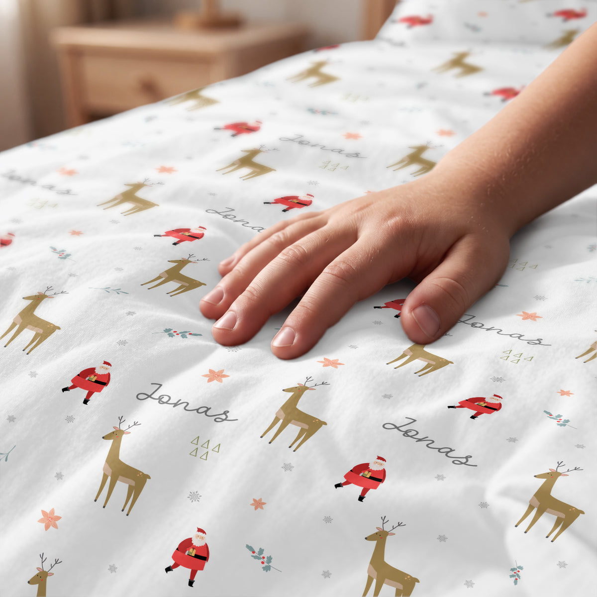 Hand streicht über die Weihnachts-Bettwäsche mit Rentier