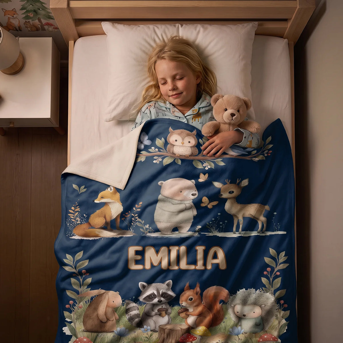 Mädchen schläft unter der dunkelblauen Waldtiere-Decke mit dem Namen Emilia