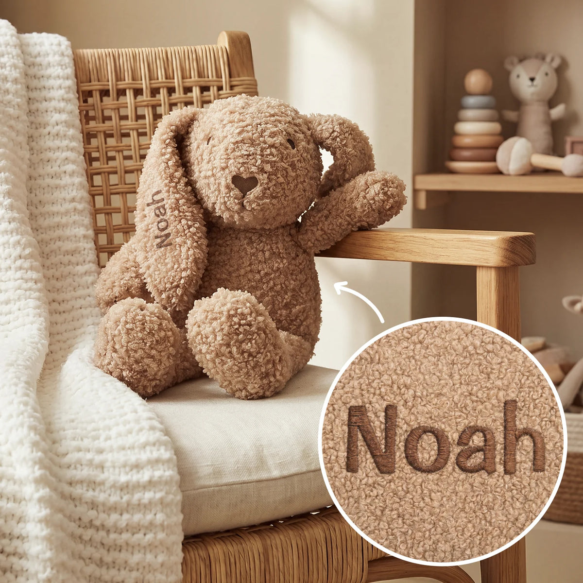 Beiger Kuschelhase sitzt auf einem Stuhl, Detailansicht der Stickerei „Noah“