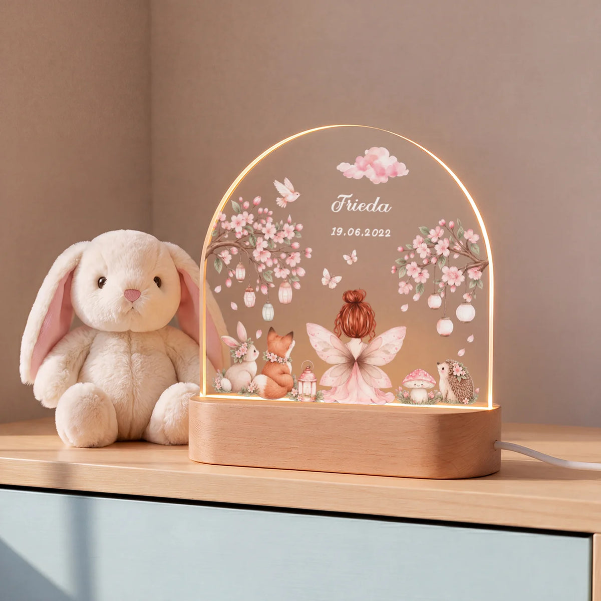Feen-Nachtlicht mit Kirschblüten neben einem Plüschhasen