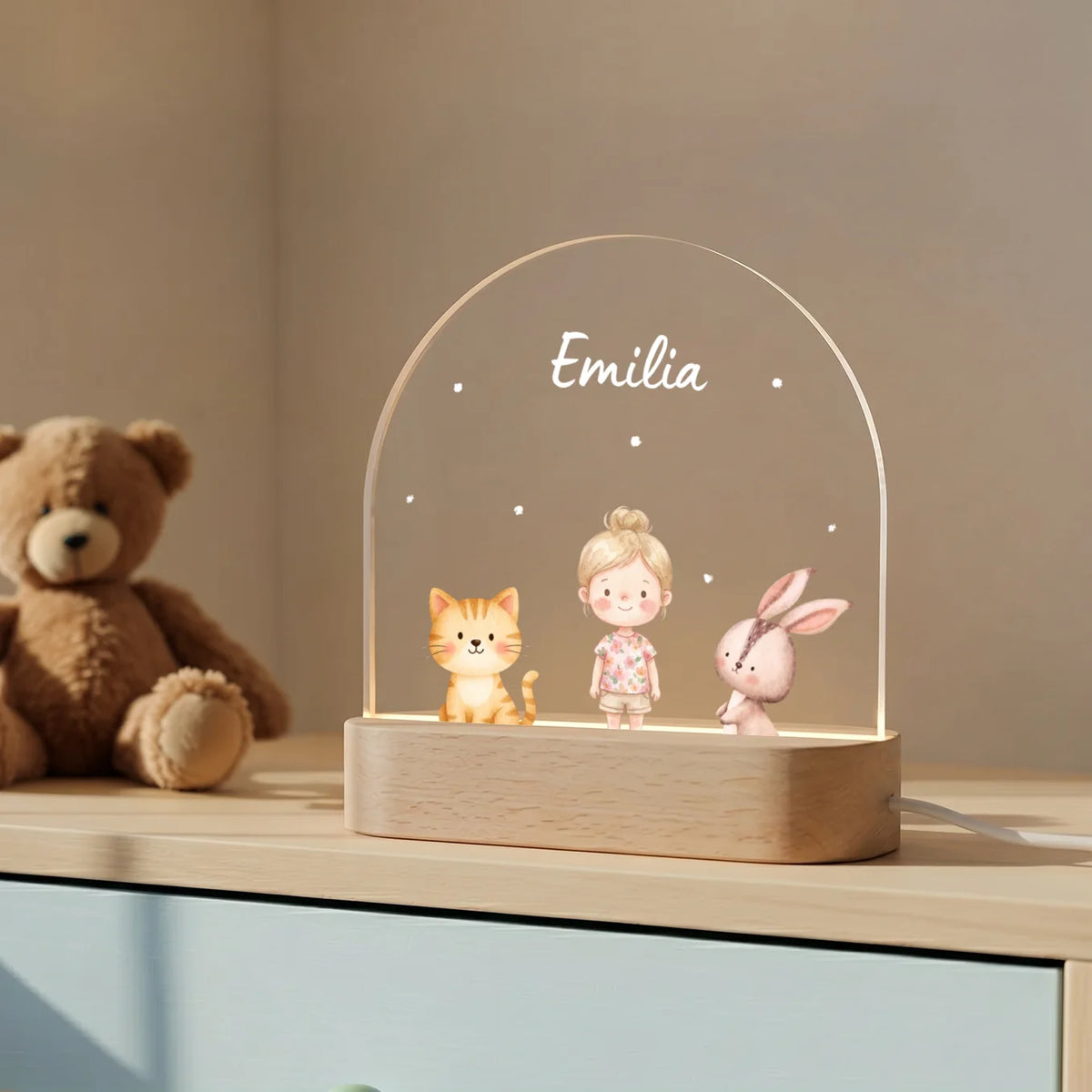 Lieblingstiere-Nachtlicht mit Namen neben einem Teddybär auf der Kommode