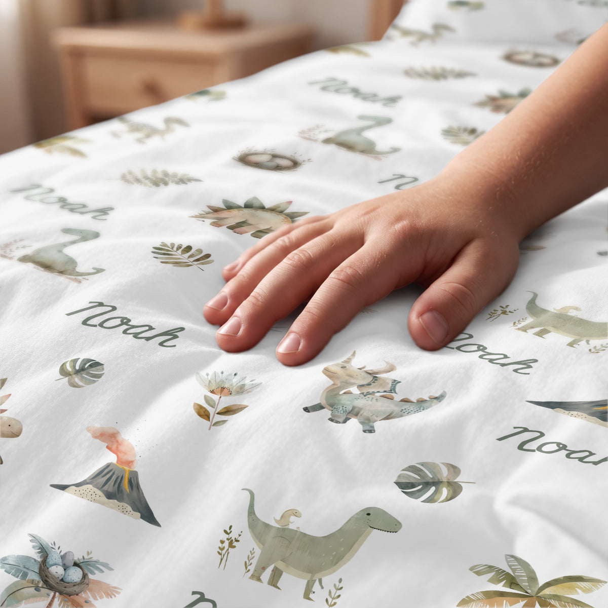 Hand streicht über die Dino-Bettwäsche mit Dino-Motiven