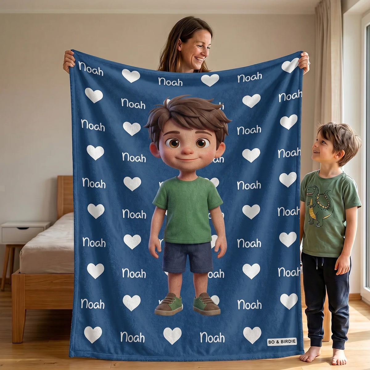 Mutter und Sohn halten die blaue Decke mit Cartoon-Figur und Namen Noah